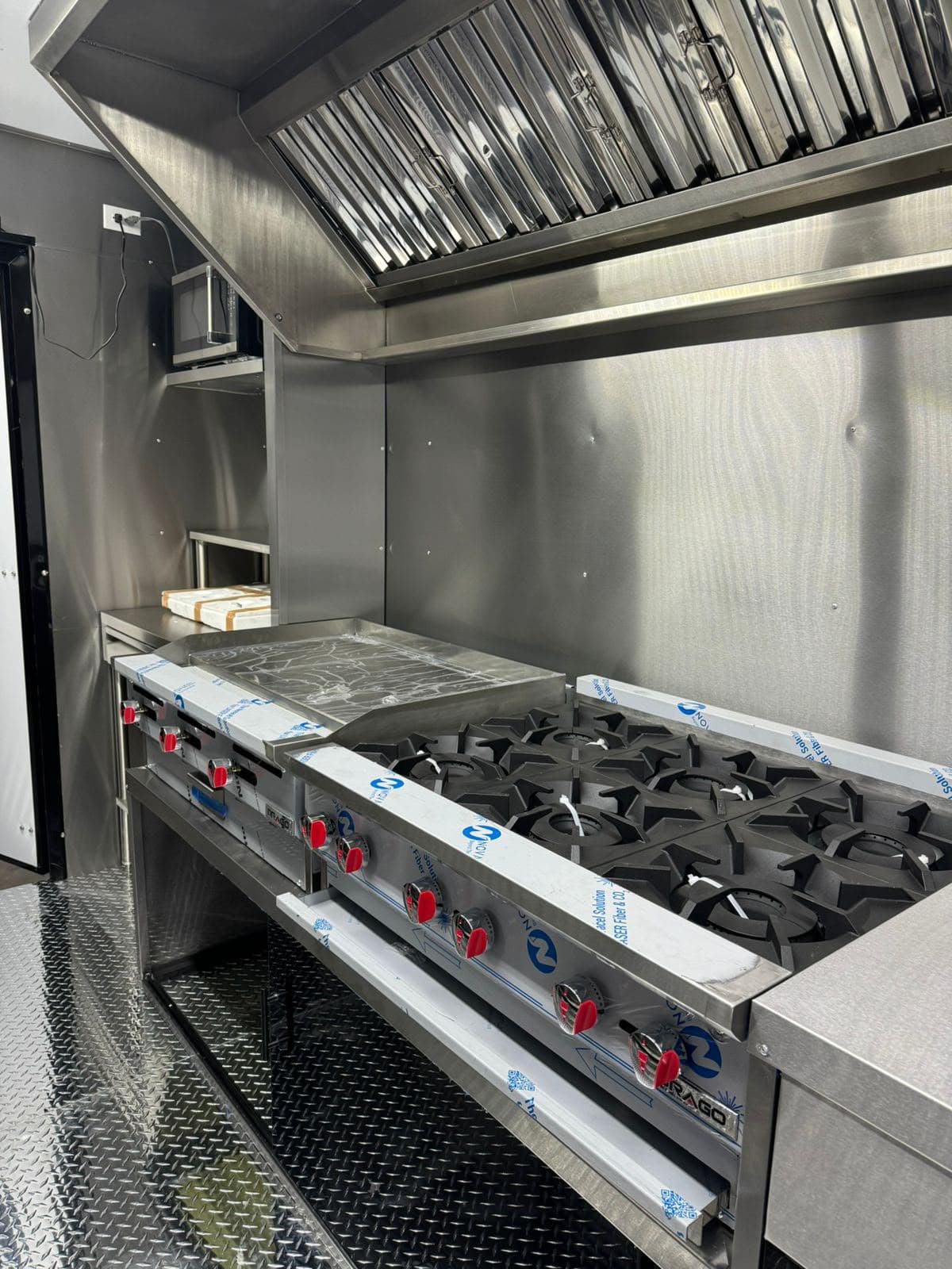 Vista 5 del interior del food truck con equipo de cocina y superficies de acero inoxidable.