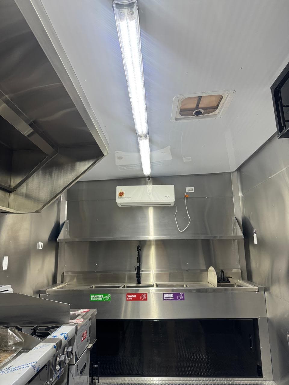 Vista 7 del interior del food truck con equipo de cocina y superficies de acero inoxidable.